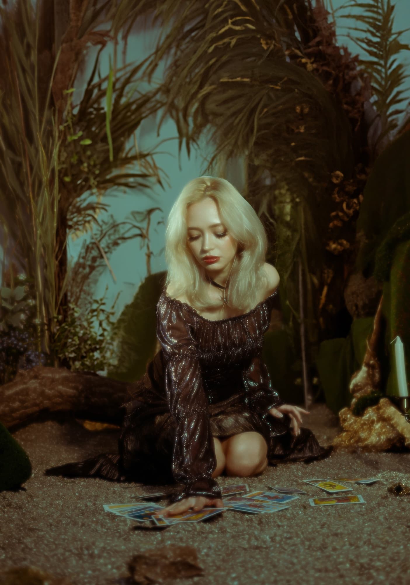 Blonde woman in a sequin dress among palm leaves