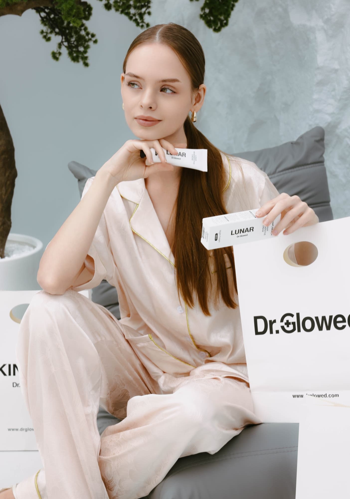 Woman in silk pyjamas with Dr. Glowe skincare