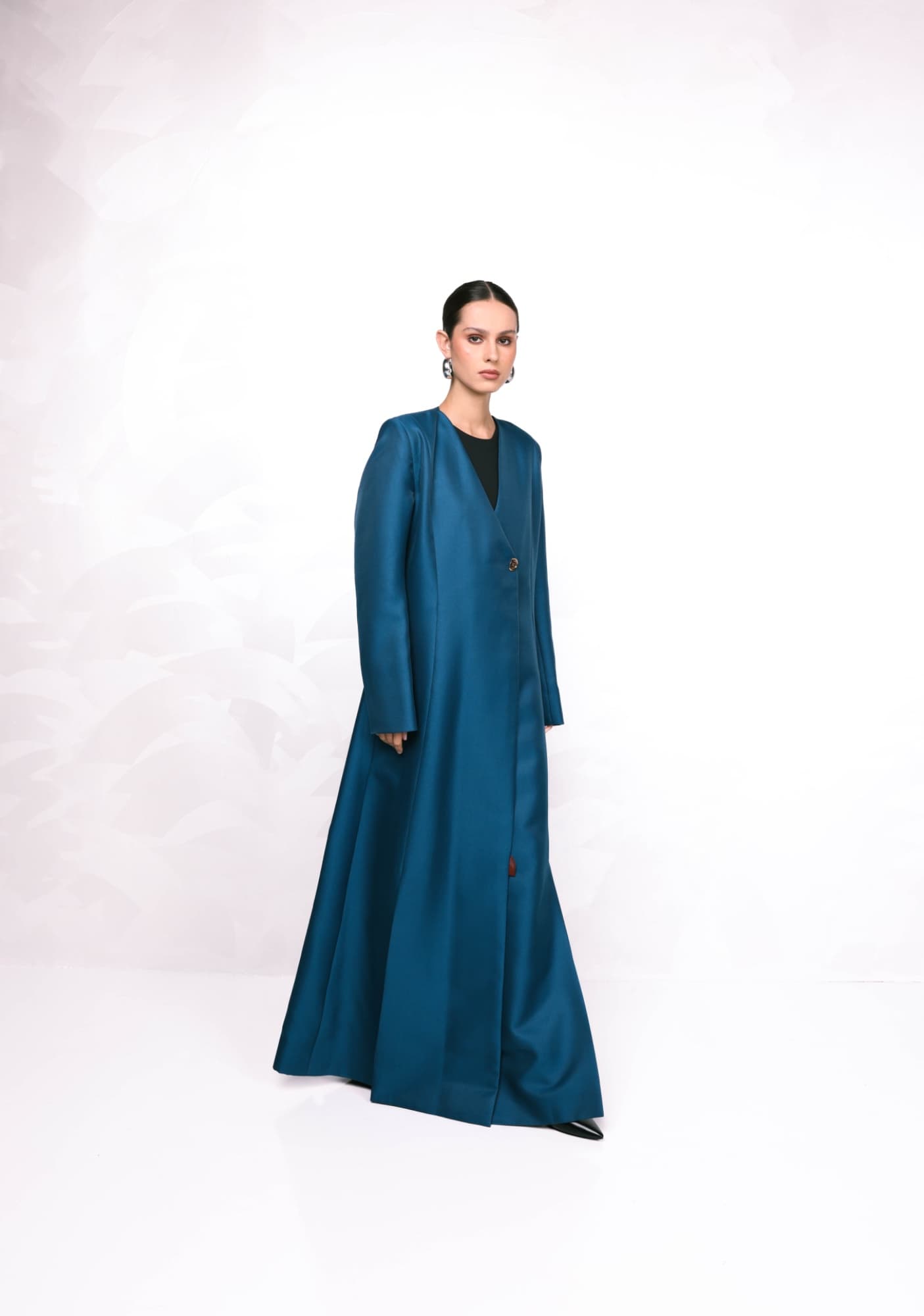 Model in a long blue dress on a white studio background