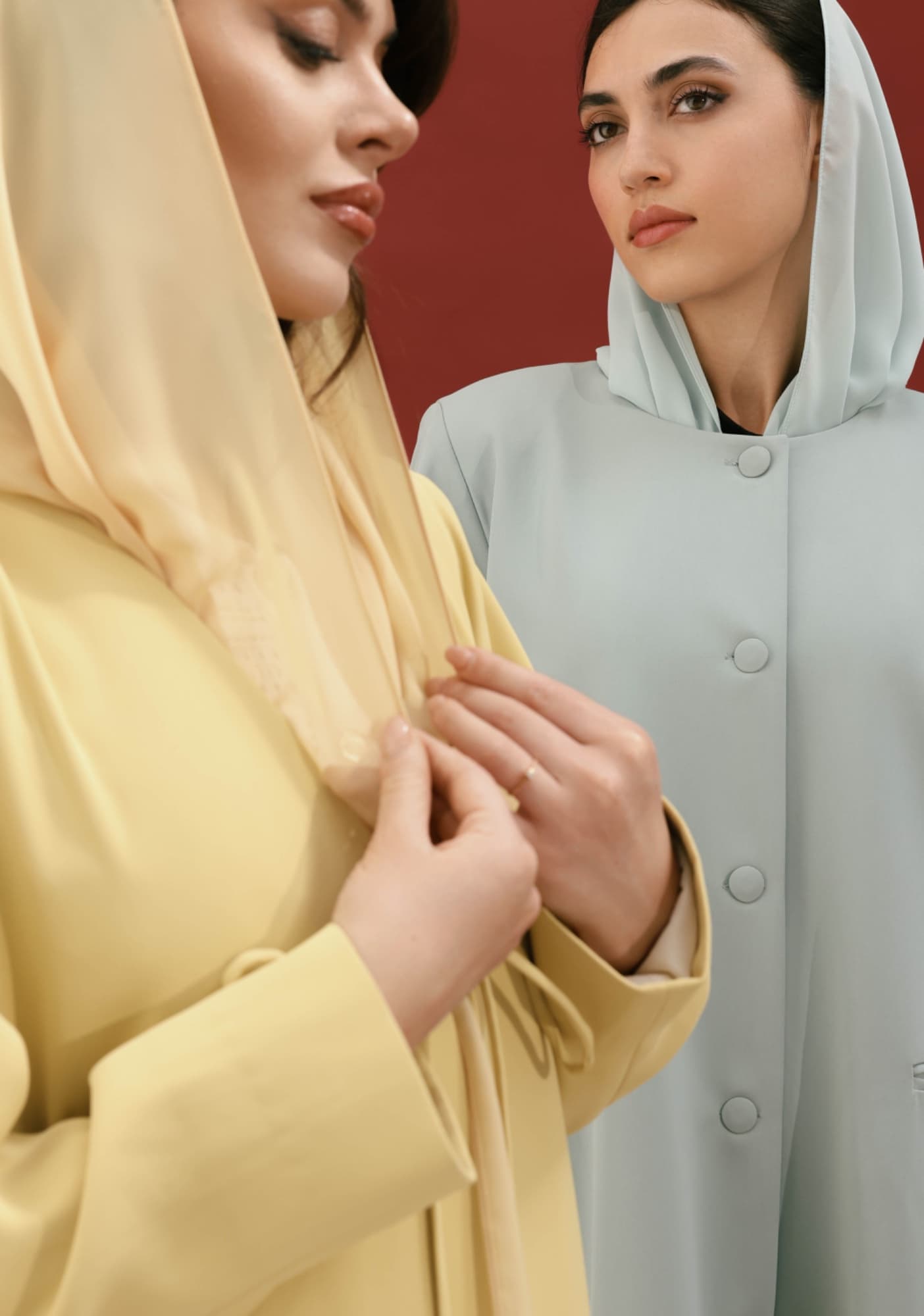 Two women in soft yellow and grey hooded outfits